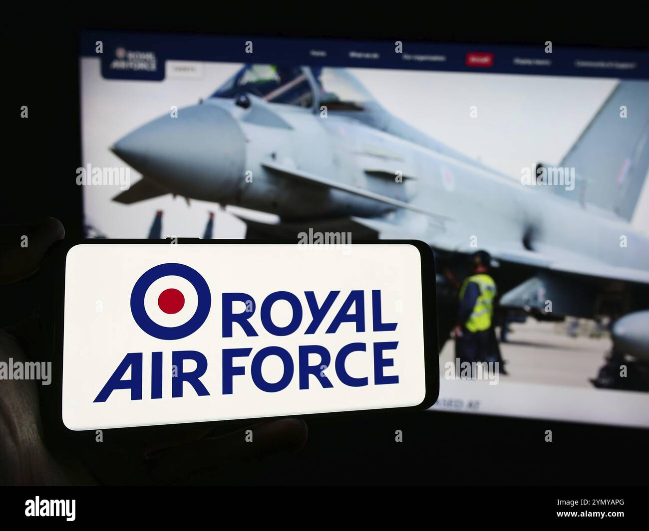 Stuttgart, Deutschland, 25.03.2024: Person, die ein Mobiltelefon mit dem Logo der britischen Luft- und Raumfahrtwaffe Royal Air Force (RAF) vor der Webseite hält Stockfoto