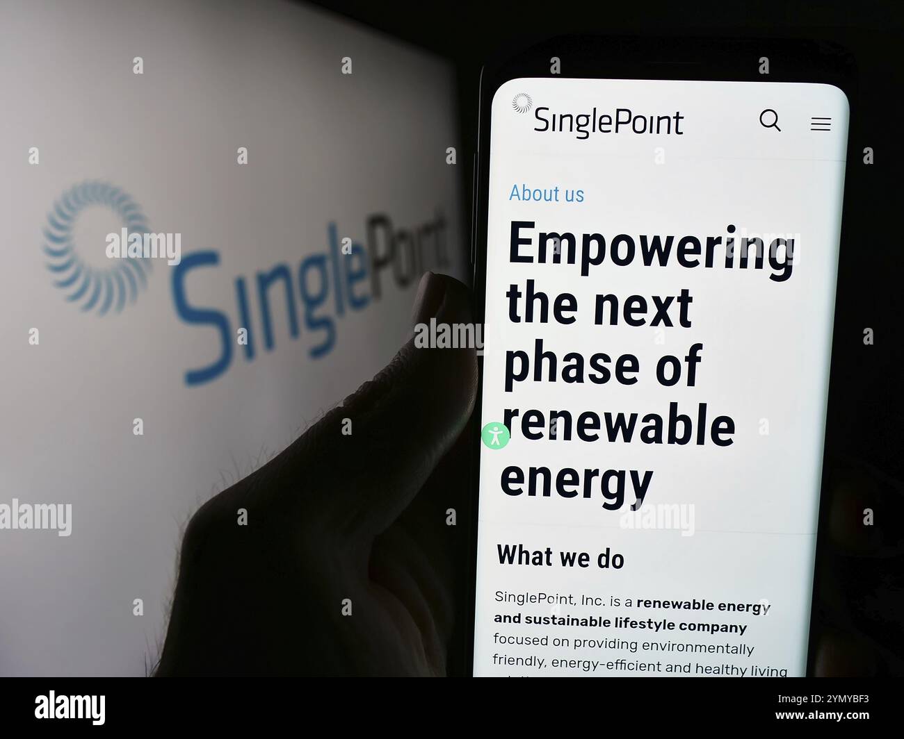 Stuttgart, Deutschland, 05.06.2024: Person mit Smartphone und Website des US-amerikanischen Erneuerbare-Energien-Unternehmens Singlepoint Inc. Vor dem Logo. Konzentrieren Sie sich auf Cent Stockfoto