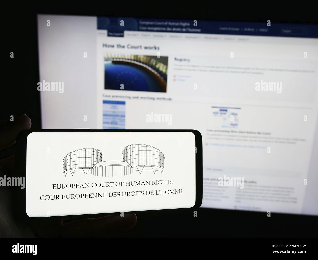 Stuttgart, Deutschland, 21.05.2024: Person, die ein Smartphone mit dem Logo des Internationalen Gerichtshofs für Menschenrechte (EMRK) vor der Website hält. Stockfoto
