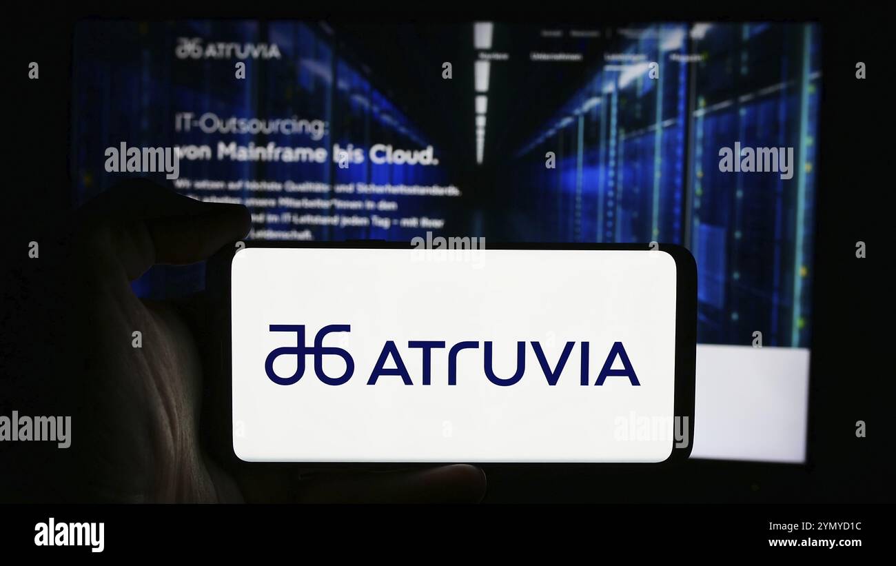 Stuttgart, 15.07.2024: Person mit Mobiltelefon mit Logo des deutschen IT-Unternehmens Atruvia AG vor der Business-Webseite. F Stockfoto