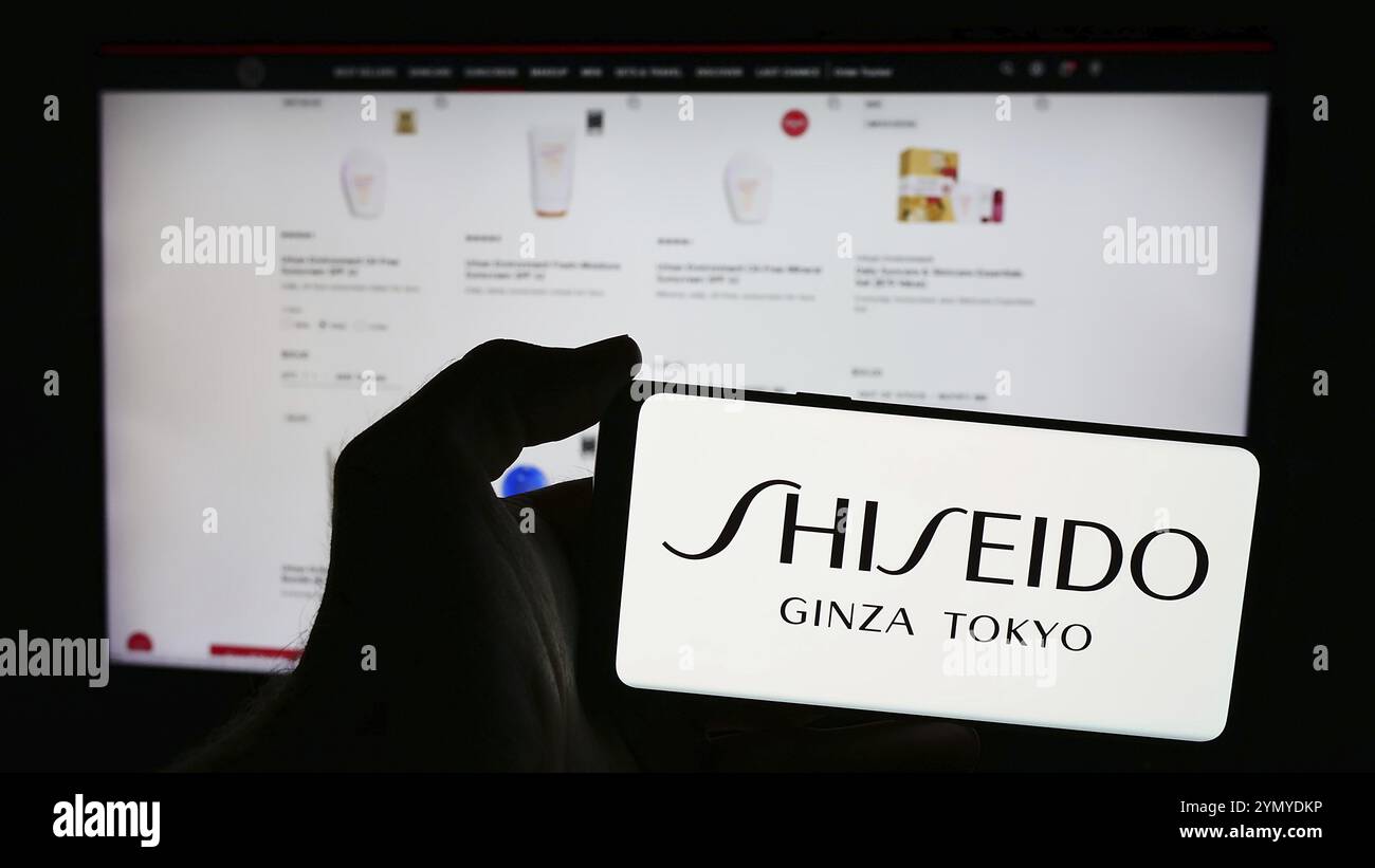 Stuttgart, 24.06.2024: Person mit Handy mit Logo des japanischen Kosmetikunternehmens Shiseido Co. Ltd. Vor der Webseite. Fokus Stockfoto