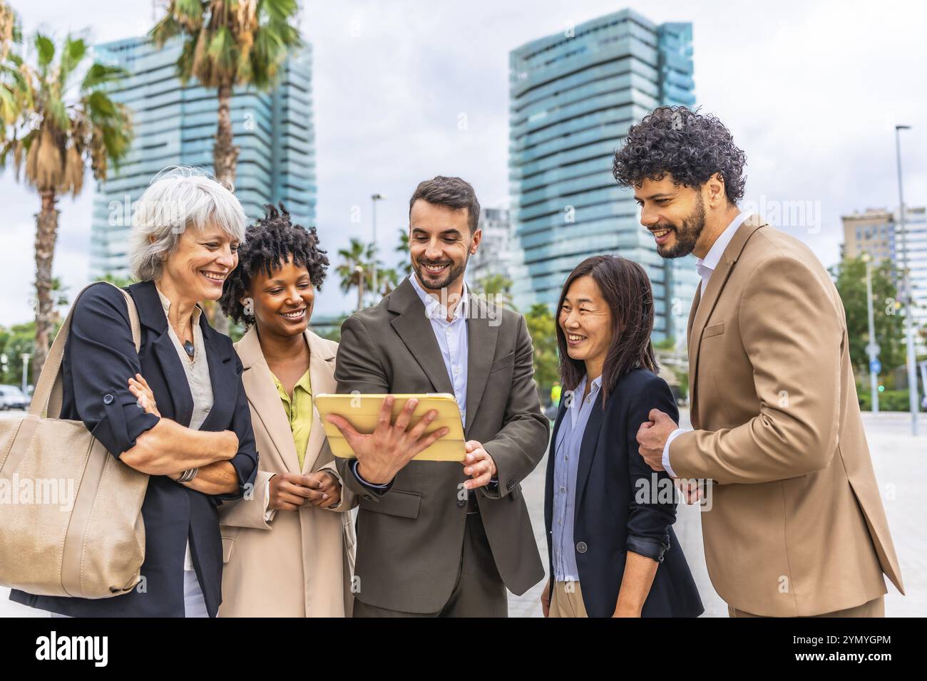 Verschiedene Geschäftsleute, die ein digitales Tablet nutzen, stehen in der Stadt zusammen Stockfoto