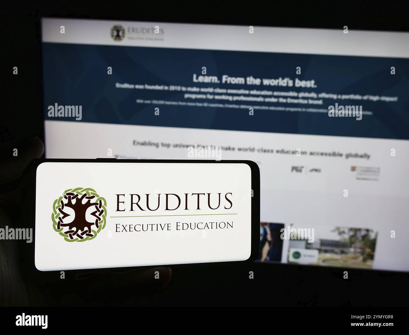 Stuttgart, Deutschland, 03-06-2024: Person mit Smartphone mit Logo des singapurischen Unternehmens Eruditus Executive Education vor der Website. Konzentrieren Sie sich auf Stockfoto