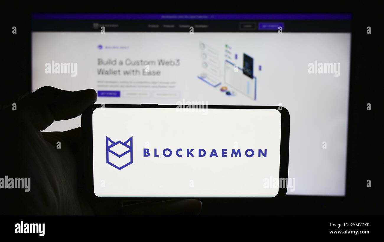 Stuttgart, Deutschland, 03.06.2024: Person, die ein Mobiltelefon mit dem Logo des Blockchain-Softwareunternehmens Blockdaemon Inc. Vor der Business-Webseite hält. Fokus Stockfoto