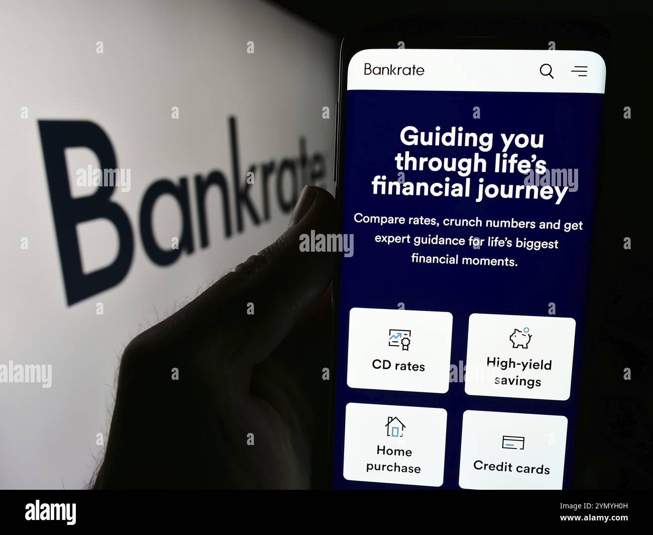 Stuttgart, Deutschland, 05-03-2024: Person, die ein Mobiltelefon hält, mit Webseite des US-amerikanischen Finanzunternehmens Bankrate LLC vor dem Geschäftslogo. Konzentrieren Sie sich auf Stockfoto