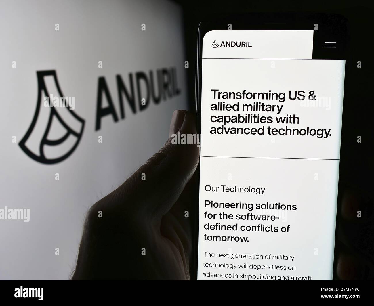 Stuttgart, Deutschland, 21.05.2024: Person, die ein Mobiltelefon hält, mit Webseite des US-amerikanischen Verteidigungstechnologieunternehmens Anduril Industries Inc. Vor dem Logo. Fokus Stockfoto
