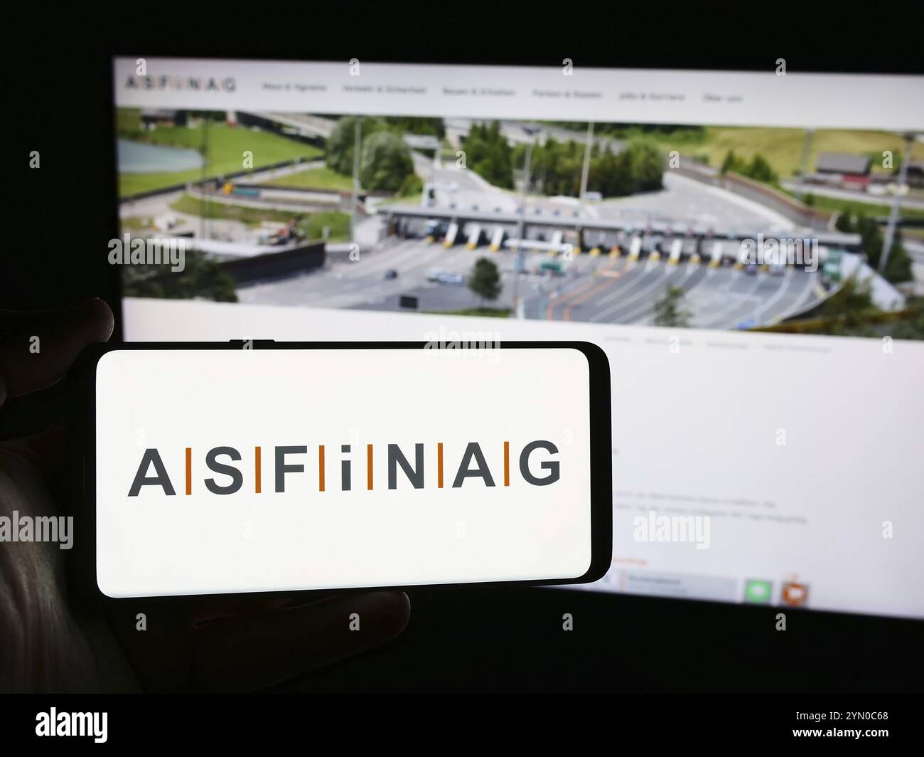 Stuttgart, Deutschland, 06.11.2024: Person mit Smartphone mit Logo des österreichischen Autobahnbetreibers ASFINAG vor der Website. Konzentrieren Sie sich auf Stockfoto