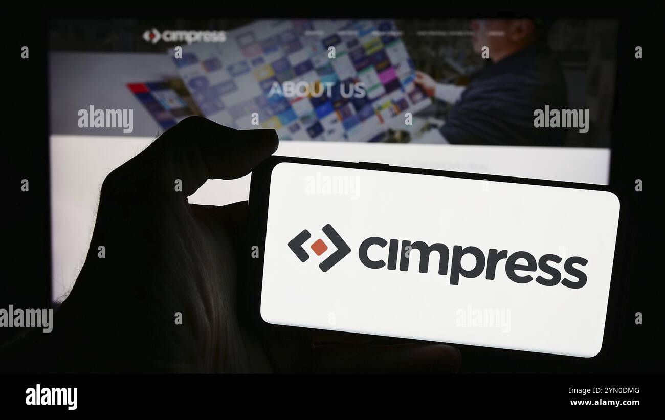 Stuttgart, Deutschland, 04.12.2024: Person, die ein Smartphone mit dem Logo der Firma Cimpress plc vor der Website hält. Konzentrieren Sie sich auf die Telefondiskretion Stockfoto