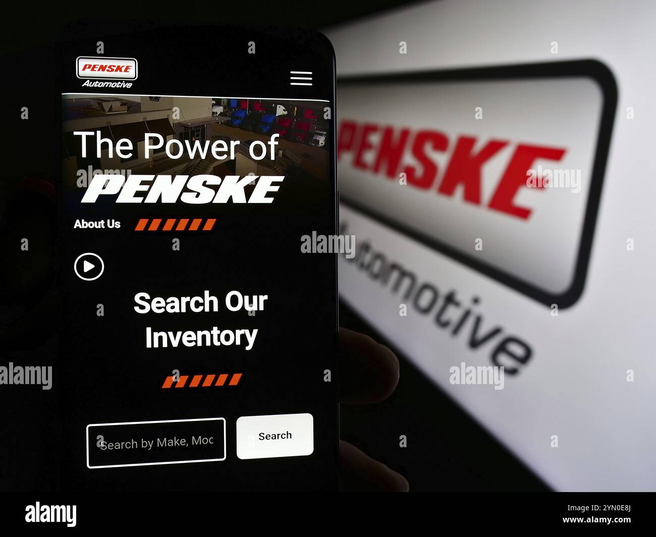 Stuttgart, Deutschland, 23.05.2024: Person, die ein Smartphone hält, mit Webseite der US-amerikanischen Händlerfirma Penske Automotive Group Inc. Vor dem Logo. Fokus Stockfoto