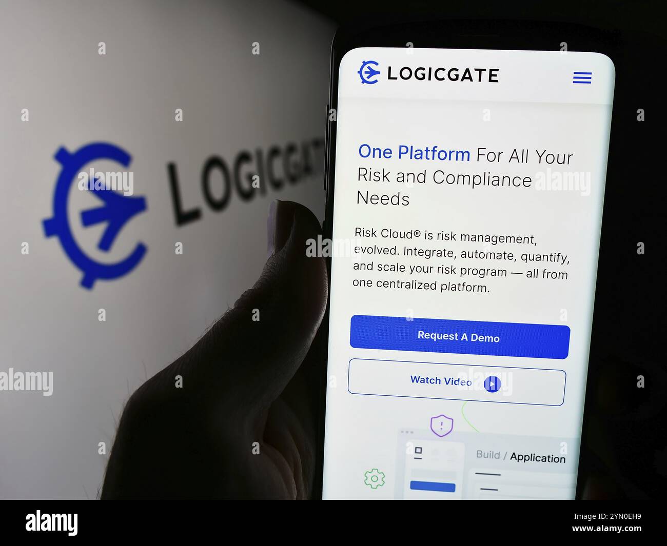 Stuttgart, Deutschland, 04.05.2024: Person, die ein Mobiltelefon hält, mit Webseite des US-amerikanischen Risikomanagement-Technologieunternehmens LogicGate Inc. Vor dem Logo. Fokus Stockfoto