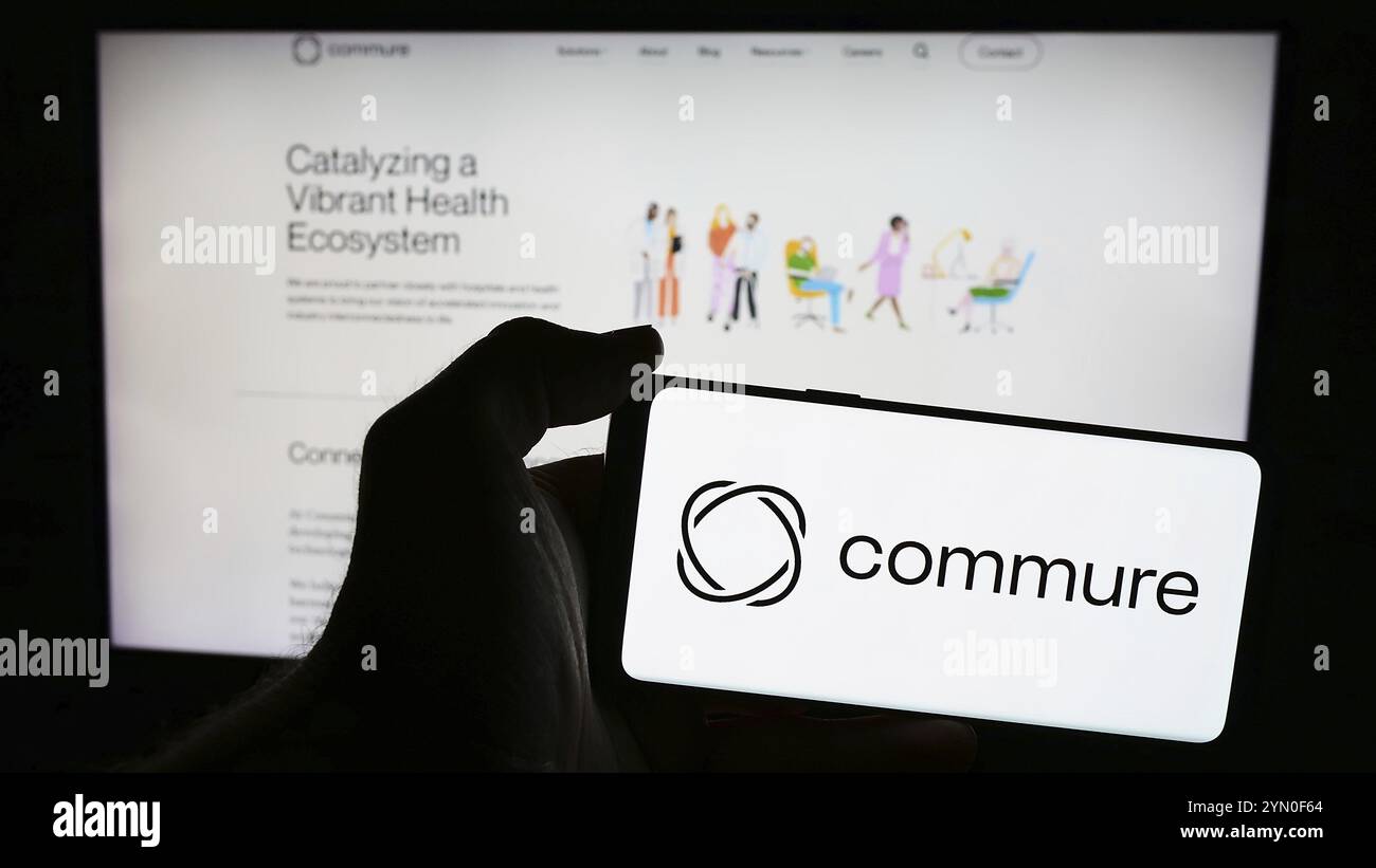 Stuttgart, Deutschland, 21.05.2024: Person mit Mobiltelefon mit Logo des amerikanischen Gesundheitssoftware-Unternehmens Commure Inc. Vor der Business-Webseite. Stockfoto