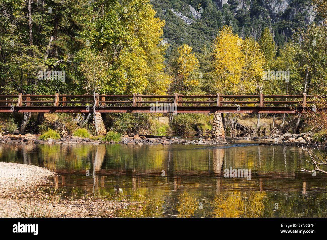 Yosemite Valley Fußgängerbrücke mit Herbstbäumen, die sich im Yosemite National Park spiegeln. Stockfoto