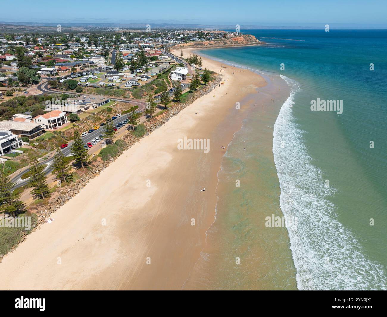 Aus der Vogelperspektive auf sanften Wellen an einem breiten Sandstrand unterhalb einer Küstenstadt am Christies Beach in Adelaide, South Australia Stockfoto