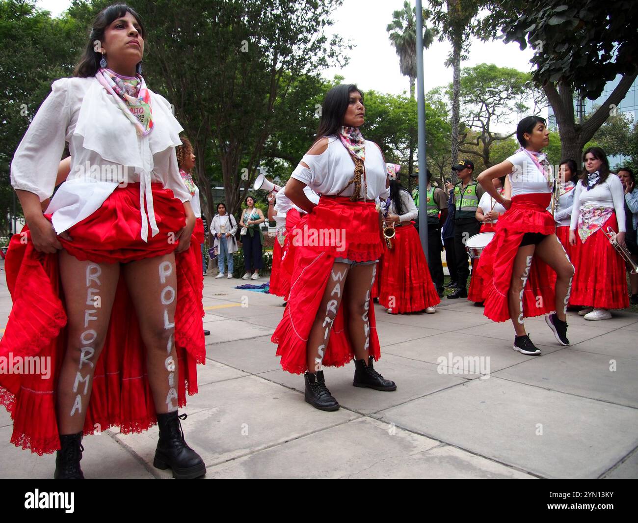 Lima, Peru. November 2024. „Polizeireform“ auf die Beine von Frauen in roten Röcken geschrieben, als sie auf der Straße von Lima im Rahmen der Aktivitäten zum Internationalen Tag zur Beseitigung der Gewalt gegen Frauen auftraten, einem Ereignis, das jährlich am 25. November, dem Tag, an dem die drei Mirabal-Schwestern Patria, Minerva und María Teresa ermordet wurden, begangen wird. In der Dominikanischen Republik am 1960. Quelle: Fotoholica Presseagentur/Alamy Live News Stockfoto