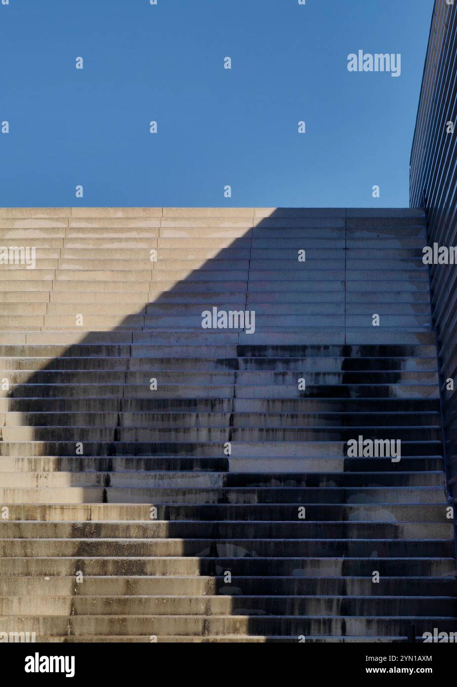 Echos des Lichts: Abstrakte Schatten auf einer Betontreppe Stockfoto