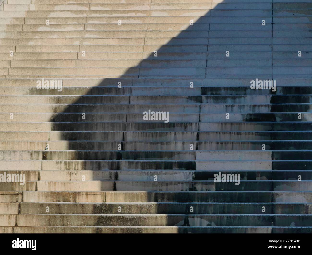 Echos des Lichts: Abstrakte Schatten auf einer Betontreppe Stockfoto