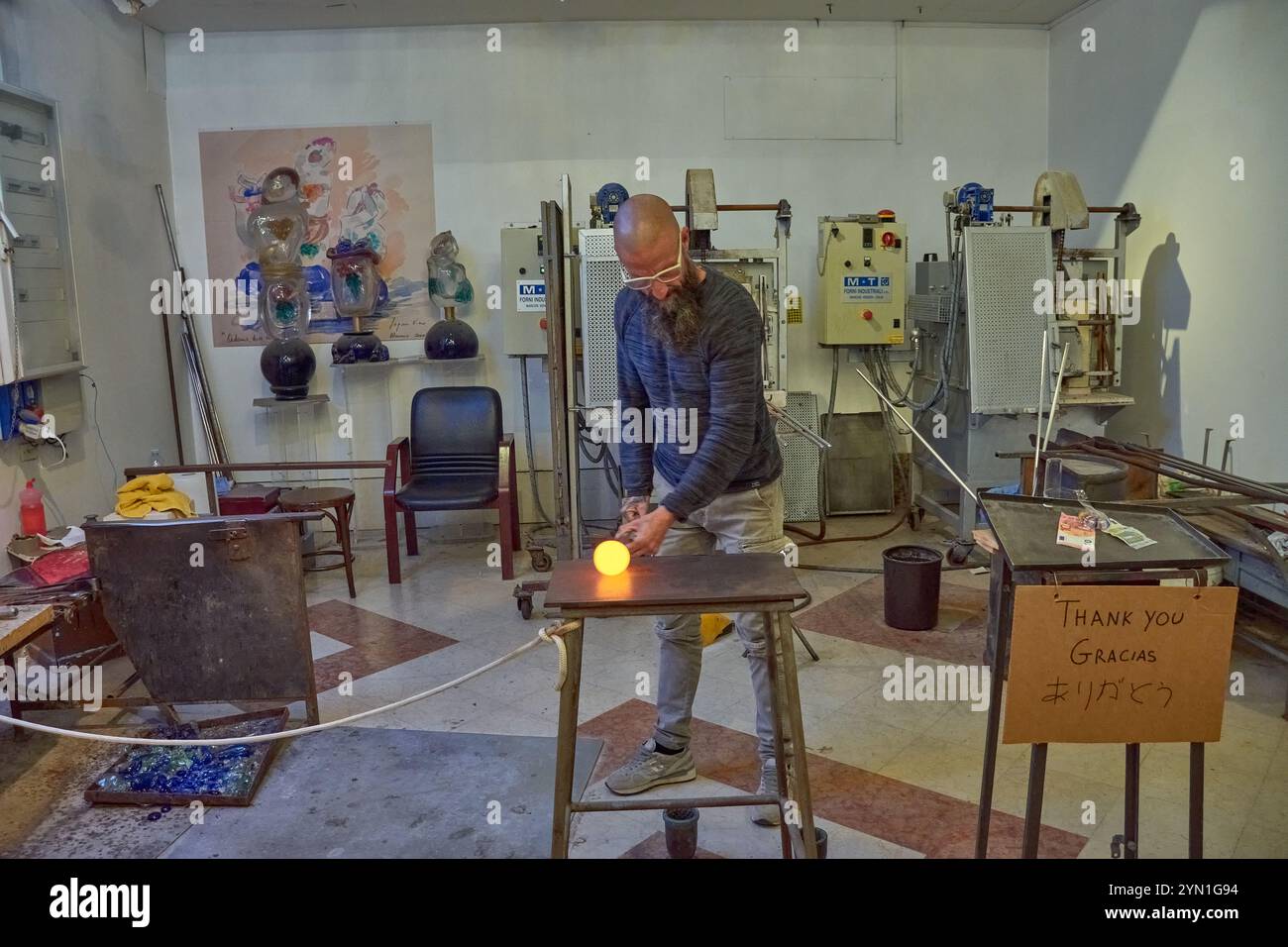 Venedig, Italien; 17. Oktober 2024: Ein schwieriger Prozess der Herstellung einer Murano-Glasfigur in einer historischen venezianischen Werkstatt. Der geschickte Handwerker formt sorgfältig Stockfoto