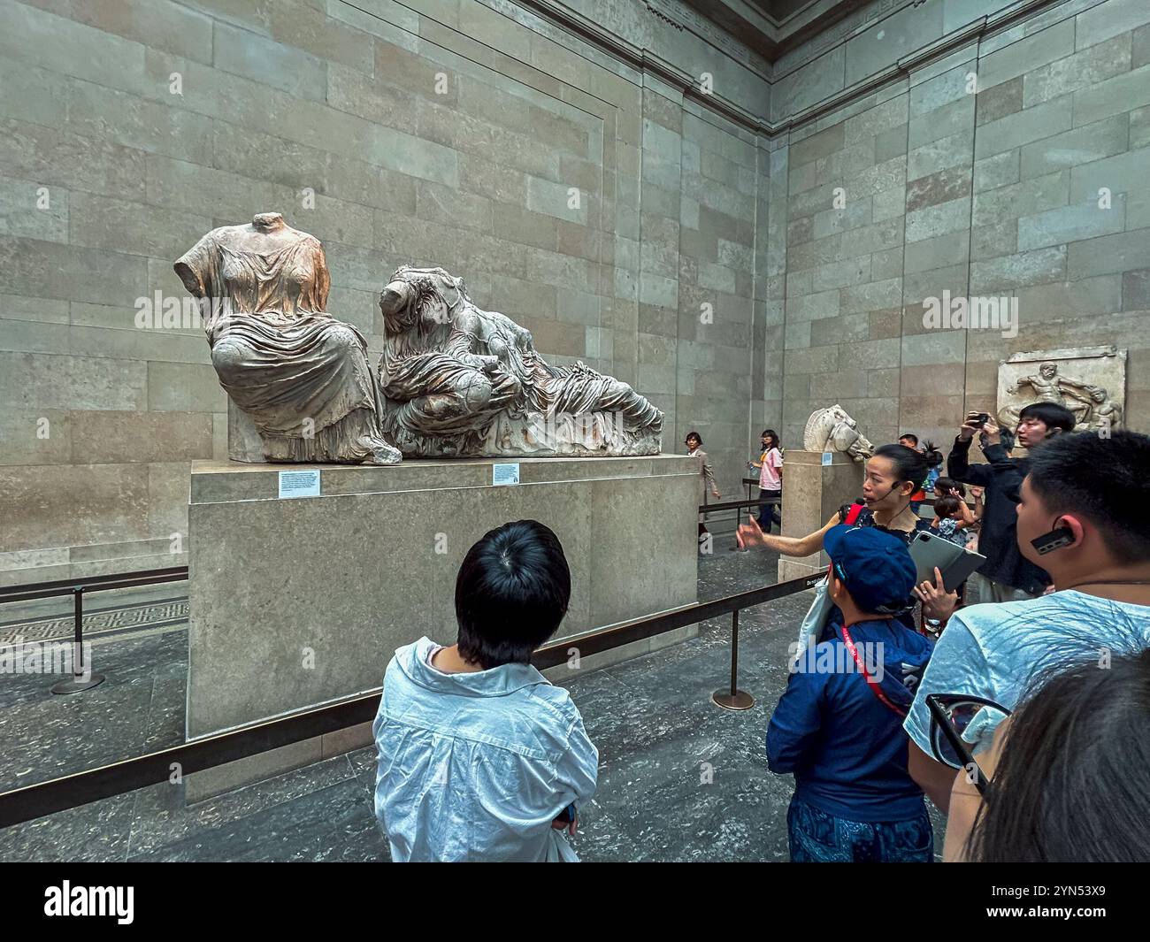 London, England, Gruppe chinesischer Kinder, die dem Reiseleiter lauschen, Inside, Ausstellung antike griechische Kunst, Sammlung, British Museum, 'The Parthenon Stockfoto