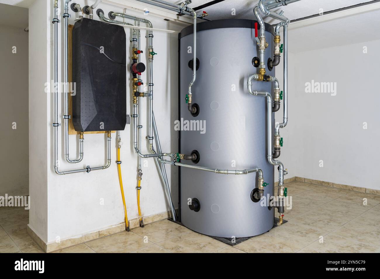 Modernes Pufferbehältersystem, verbunden mit Luft-Wasser-Wärmepumpe, für effiziente Heizeleizung und Warmwasserspeicherung in Wohnräumen Stockfoto