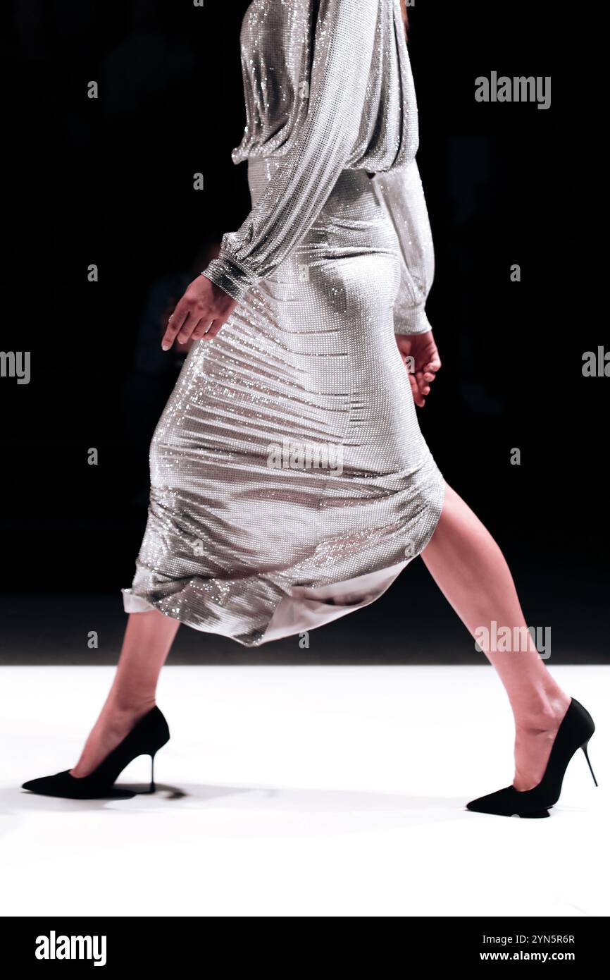 Modische Details des silberweißen Kleides zur Feier des Feiertags, Models, das auf dem Laufsteg herumläuft Stockfoto
