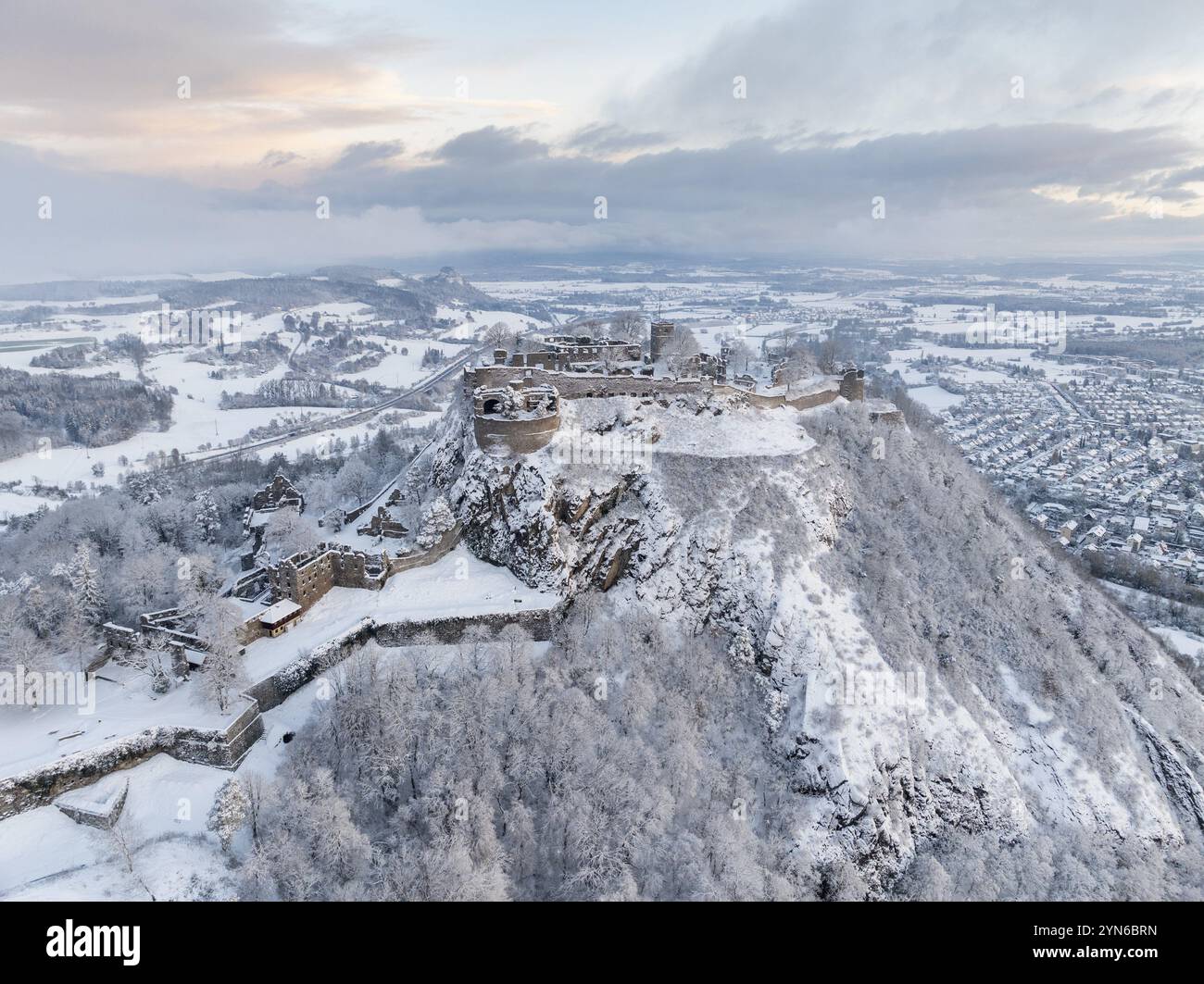 Aus der Vogelperspektive auf den schneebedeckten Hegau-Vulkan Hohentwiel mit Deutschlands größter Burgruine an einem kalten Wintermorgen, vor Sonnenaufgang, umgeben Stockfoto