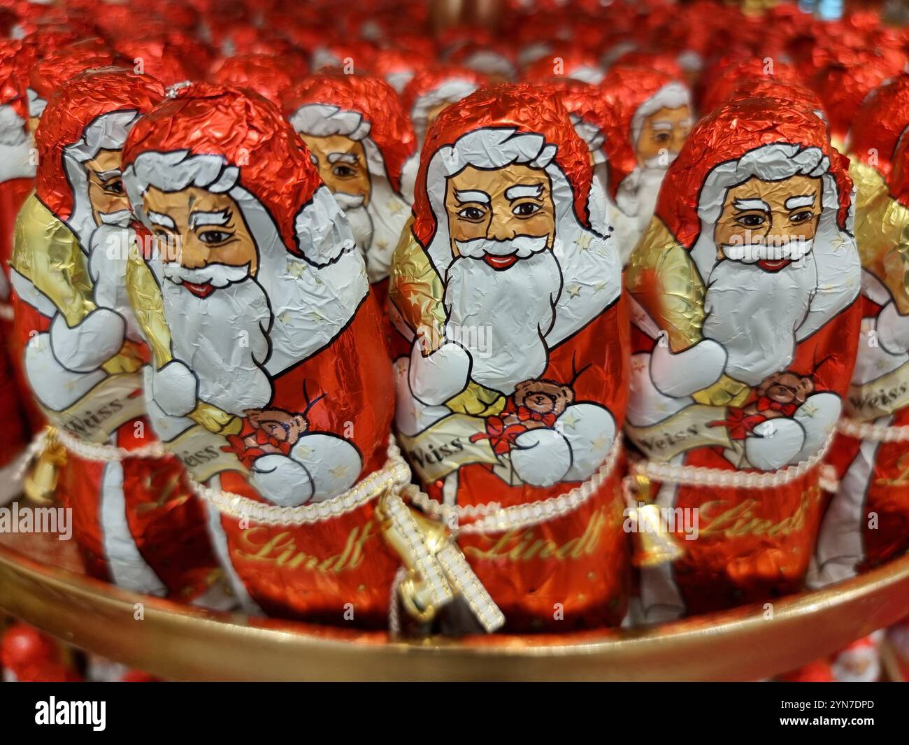 Eine Menge von Weihnachtsmannsfiguren aus roter und weißer Schokolade in Aluminiumfolie Stockfoto