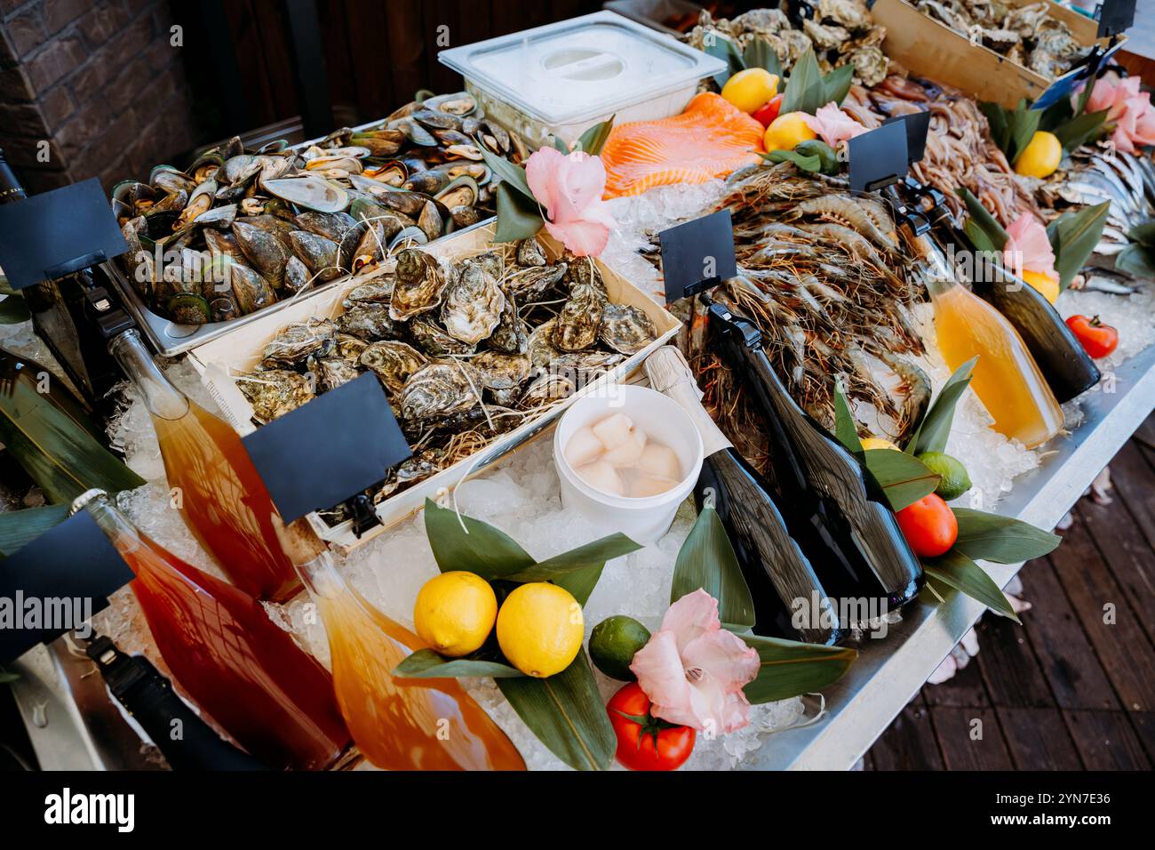 Meeresfrüchte-Buffet mit Austern, Garnelen, Getränken und frischen Beilagen auf Eis für ein Gourmetessen Stockfoto