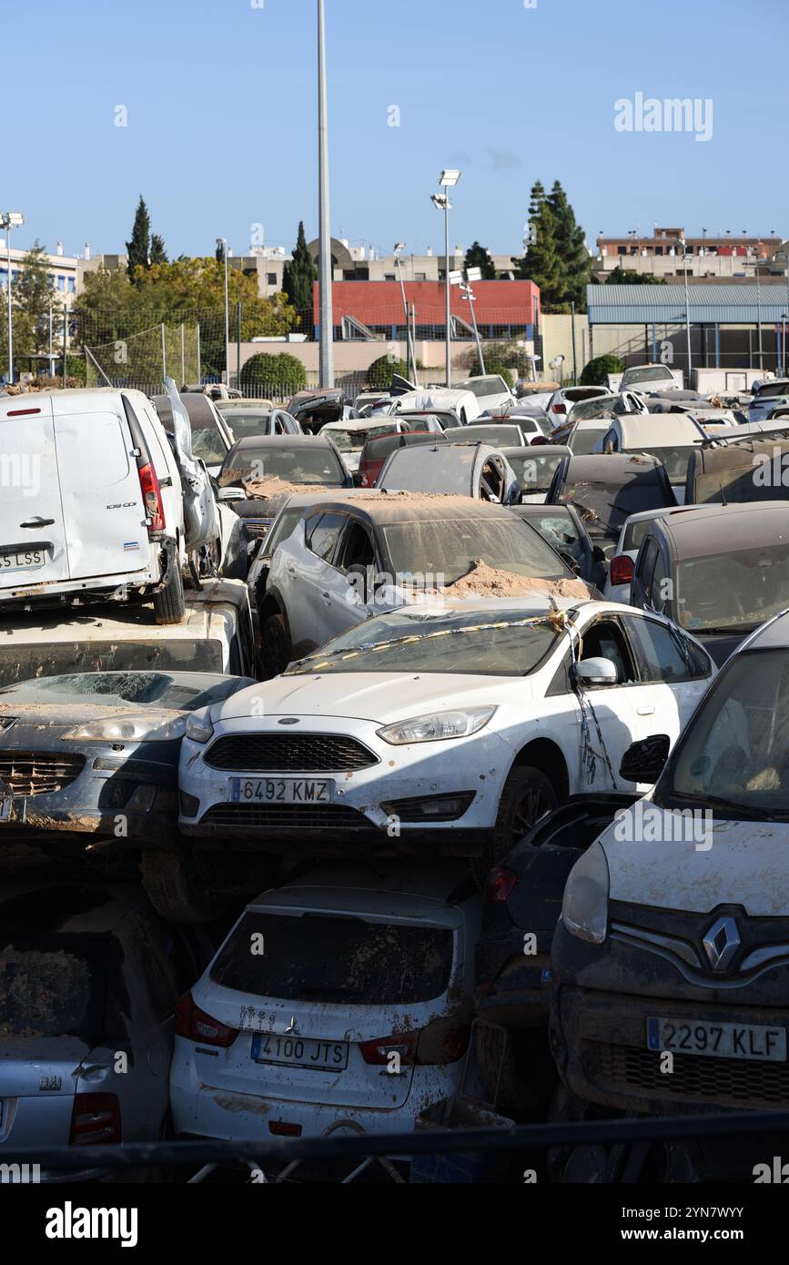 Benetússer, Spanien - 24. November 2024. Beschädigte Autos nach der Überschwemmung der DANA werden auf dem Fußballfeld und den Anlagen des Sportzentrums Benetússer (polideportivo del Benetússer) gelagert und stapelt sich dort fast einen Monat nach der Katastrophe, die die östlichen und südlichen Gebiete Spaniens heimsuchte. Tausende von Menschen verloren ihr Fahrzeug und werden auf den Autohöfen auf der Suche nach ihnen gesehen, während andere Fahrzeuge halb im Flussbett der Schlucht von Poyo (Barranco del Poyo) begraben sind. Autohändler haben aufgrund der hohen Anzahl an Anfragen Wartelisten. Quelle: Roberto Arosio/Alamy Live News Stockfoto