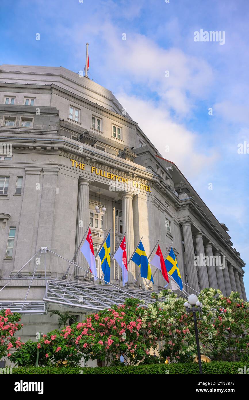 20. November 2024, Singapur: Fassade des Fullerton Hotels mit Staatsflaggen Schwedens und Singapurs zum Gedenken an seine Majestät König Carl X Stockfoto