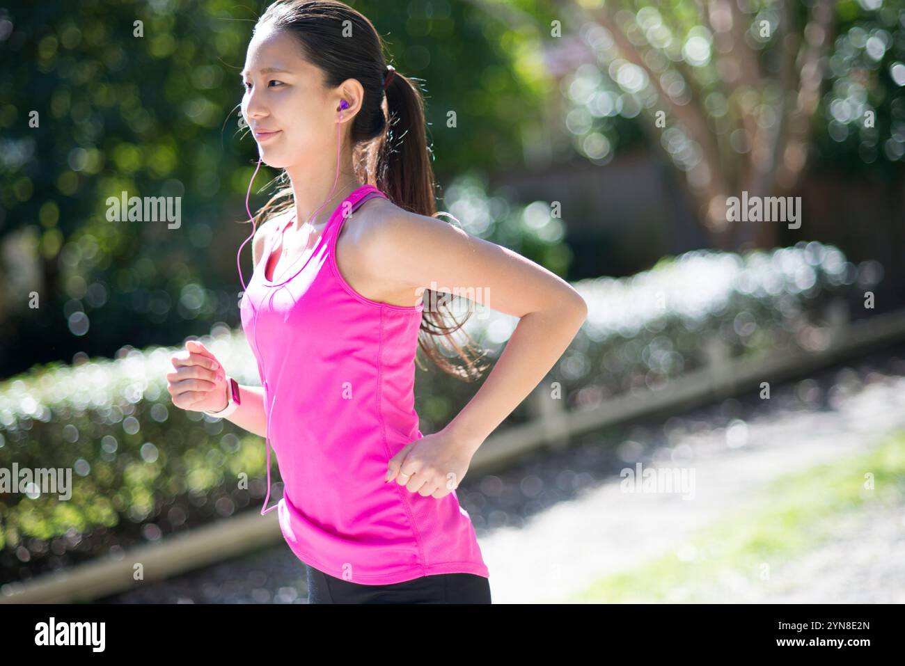 Frau, die mit Ohrhörern läuft Stockfoto