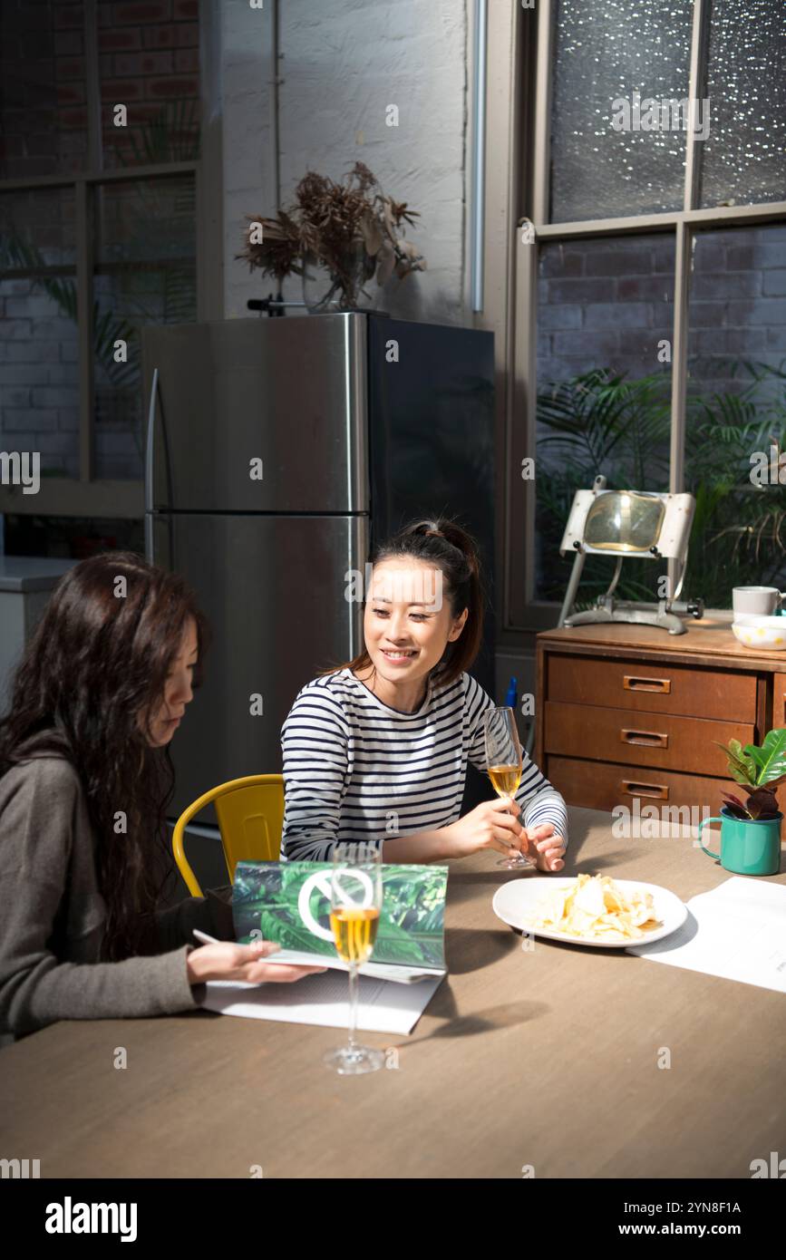 Zwei Frauen unterhalten sich bei einem Drink zu Hause Stockfoto