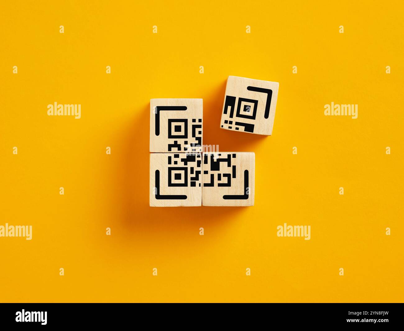 Das Codekonzept wird vervollständigt. Zum Erstellen, Entwerfen, Generieren und Scannen eines QR-Codes. Holzwürfel mit QR-Code-Symbol. Stockfoto