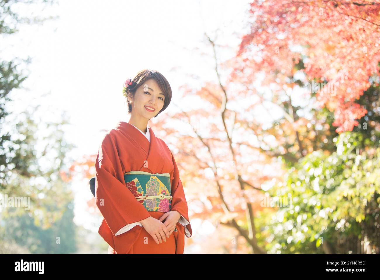 Lächelnde Frau in den 30ern, die einen Kimono trägt Stockfoto