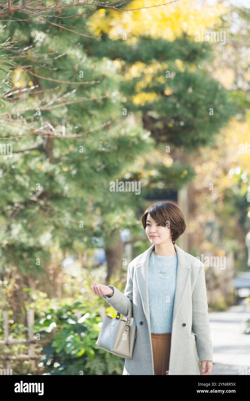 Lächelnde Frau in ihren 30ern, die draußen läuft Stockfoto