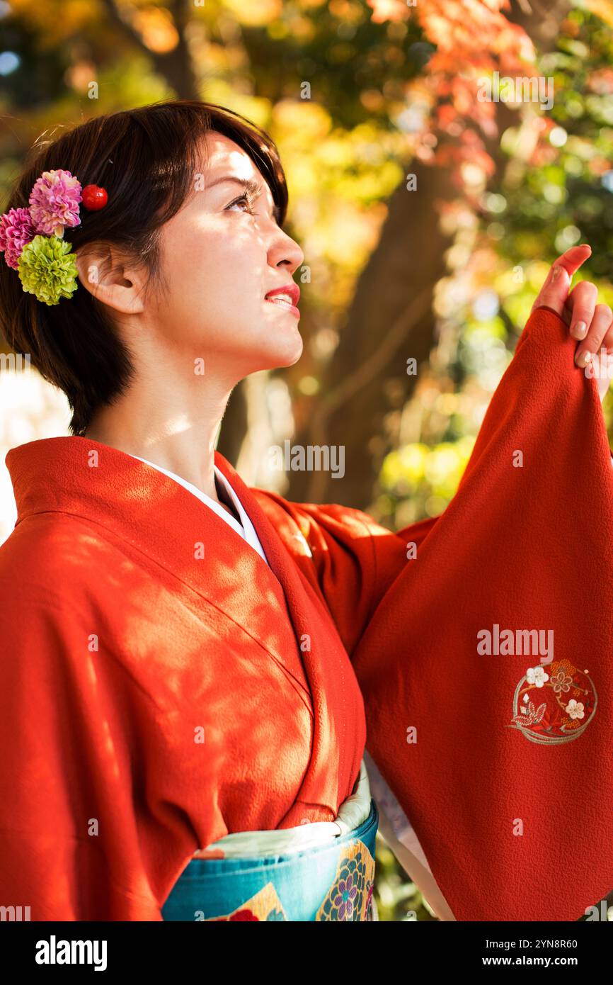 Frau in ihren 30ern im Kimono, die nach oben blickt Stockfoto