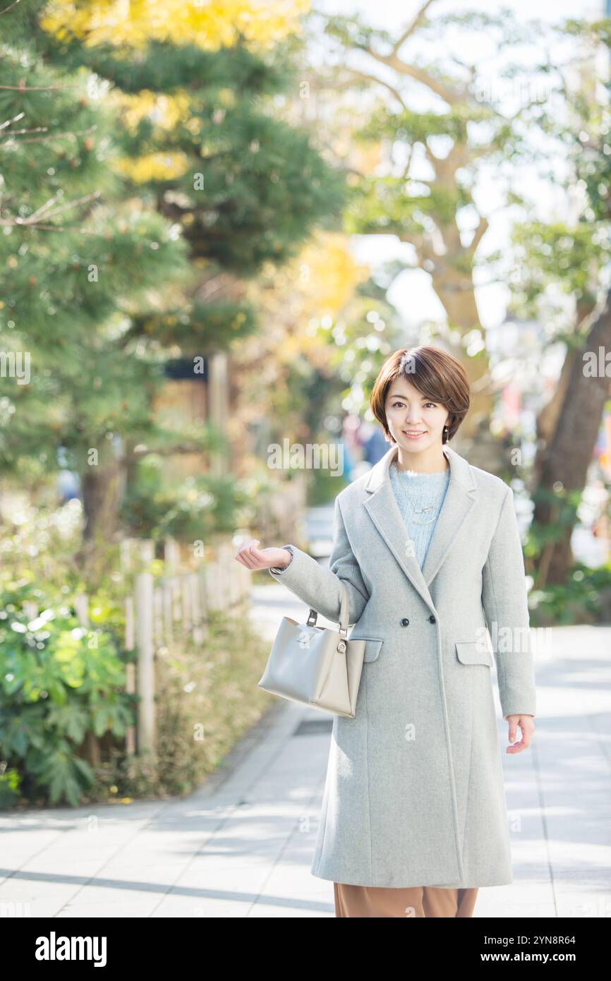 Lächelnde Frau in ihren 30ern, die draußen läuft Stockfoto