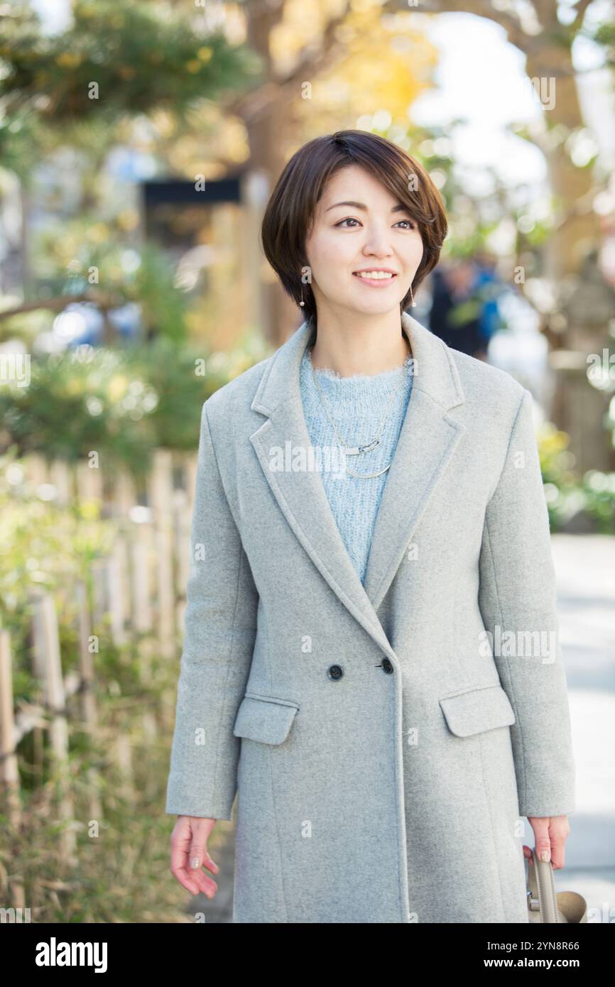 Lächelnde Frau in ihren 30ern, die draußen läuft Stockfoto