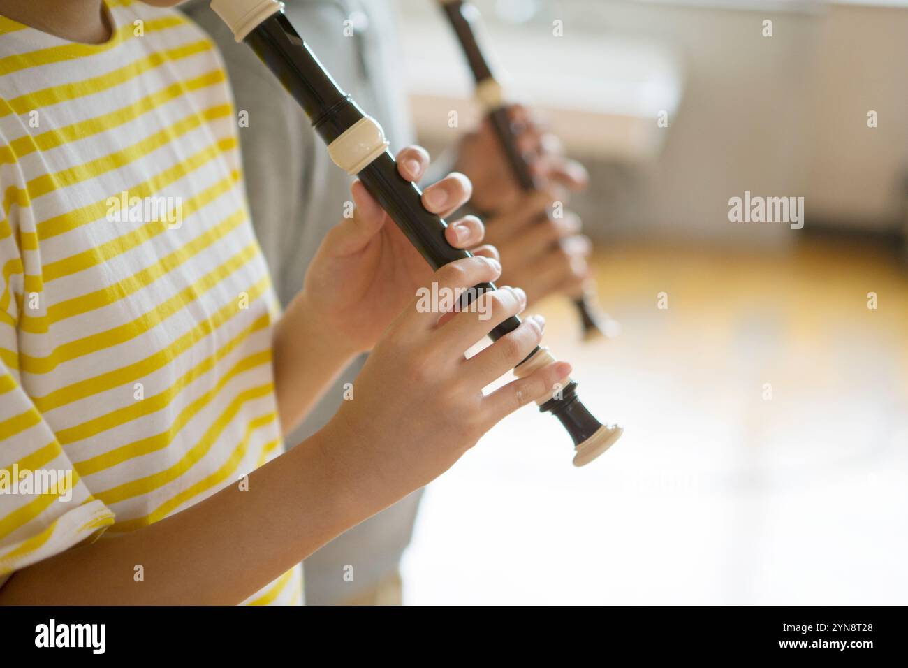 Hand eines Schuljungen, der eine Blockflöte spielt Stockfoto