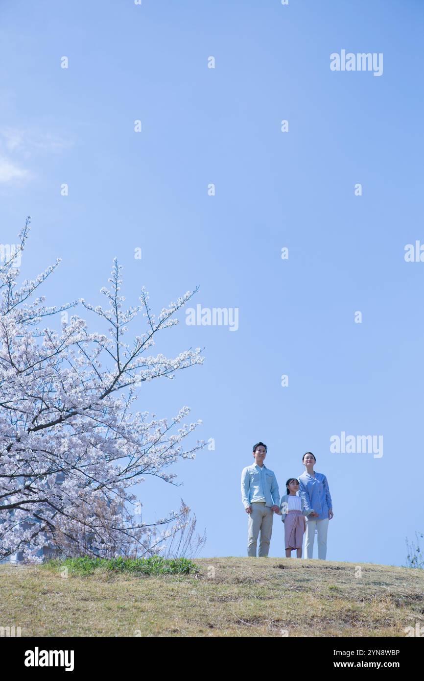 Glückliche Familie, die unter einem Kirschbaum steht Stockfoto