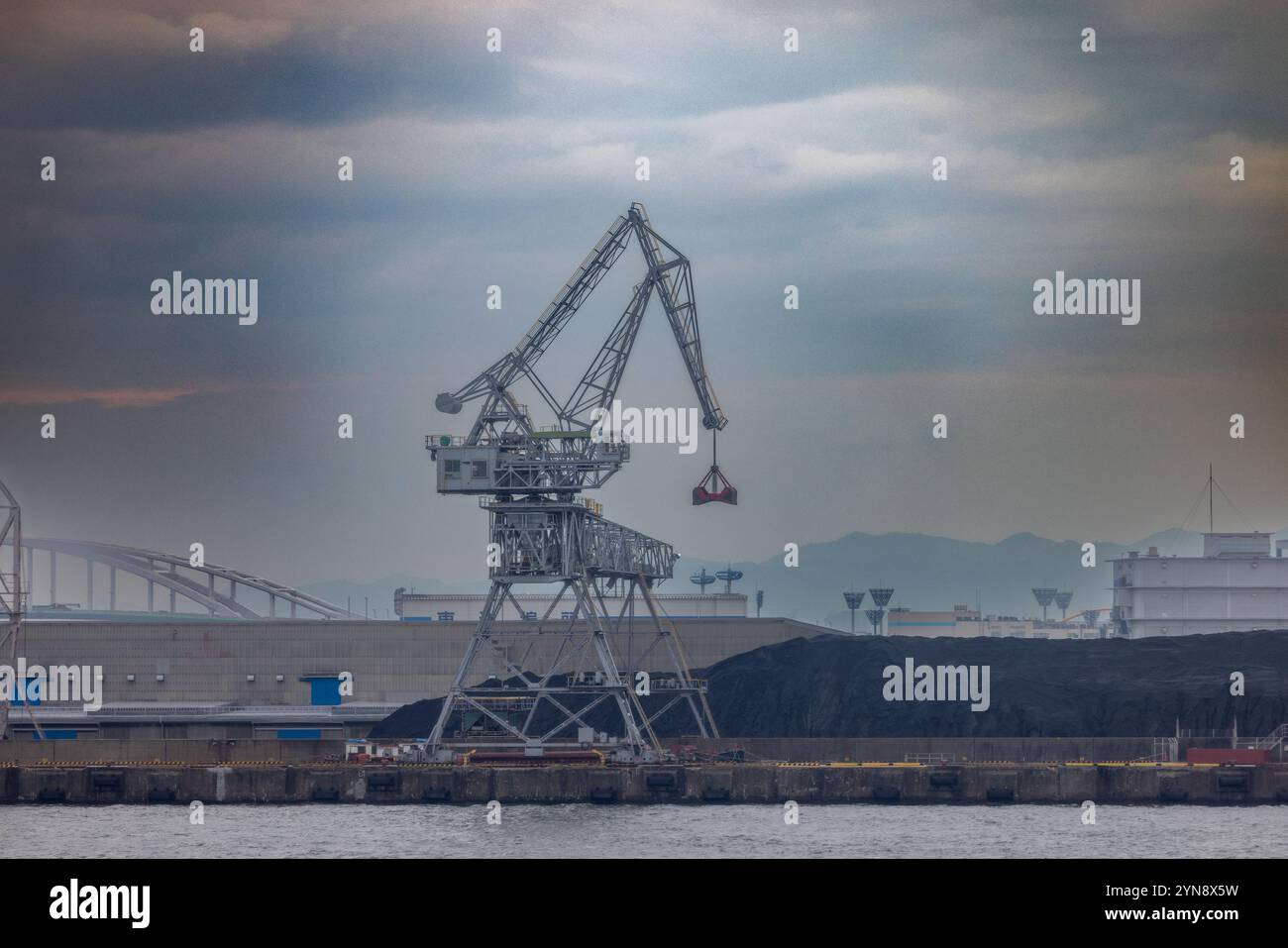 Industriekran in einem Hafen unter dramatischem Himmel Stockfoto