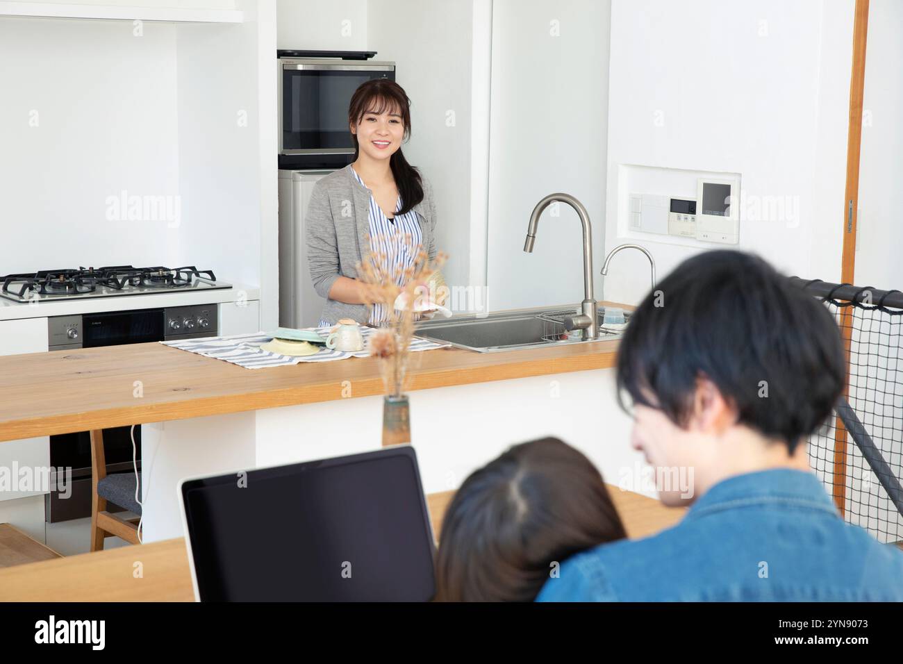 Familie spricht in offener Küche Stockfoto