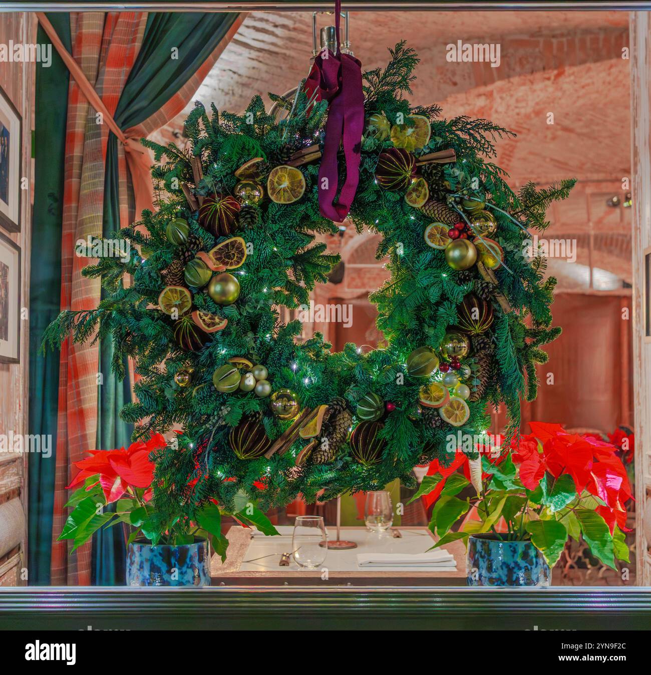 Schöne Weihnachtsfenster Dekoration mit einem Kranz aus Tannenzweigen. Stockfoto