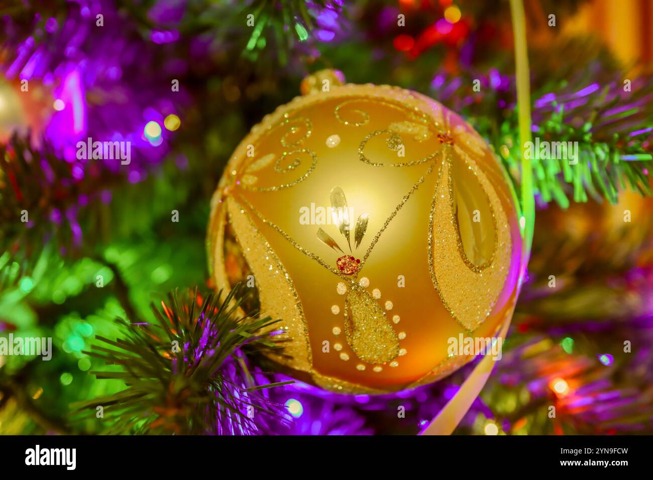 Dekoration für den Weihnachtsbaum. Goldene Kugel mit gemalten Mustern. Stockfoto