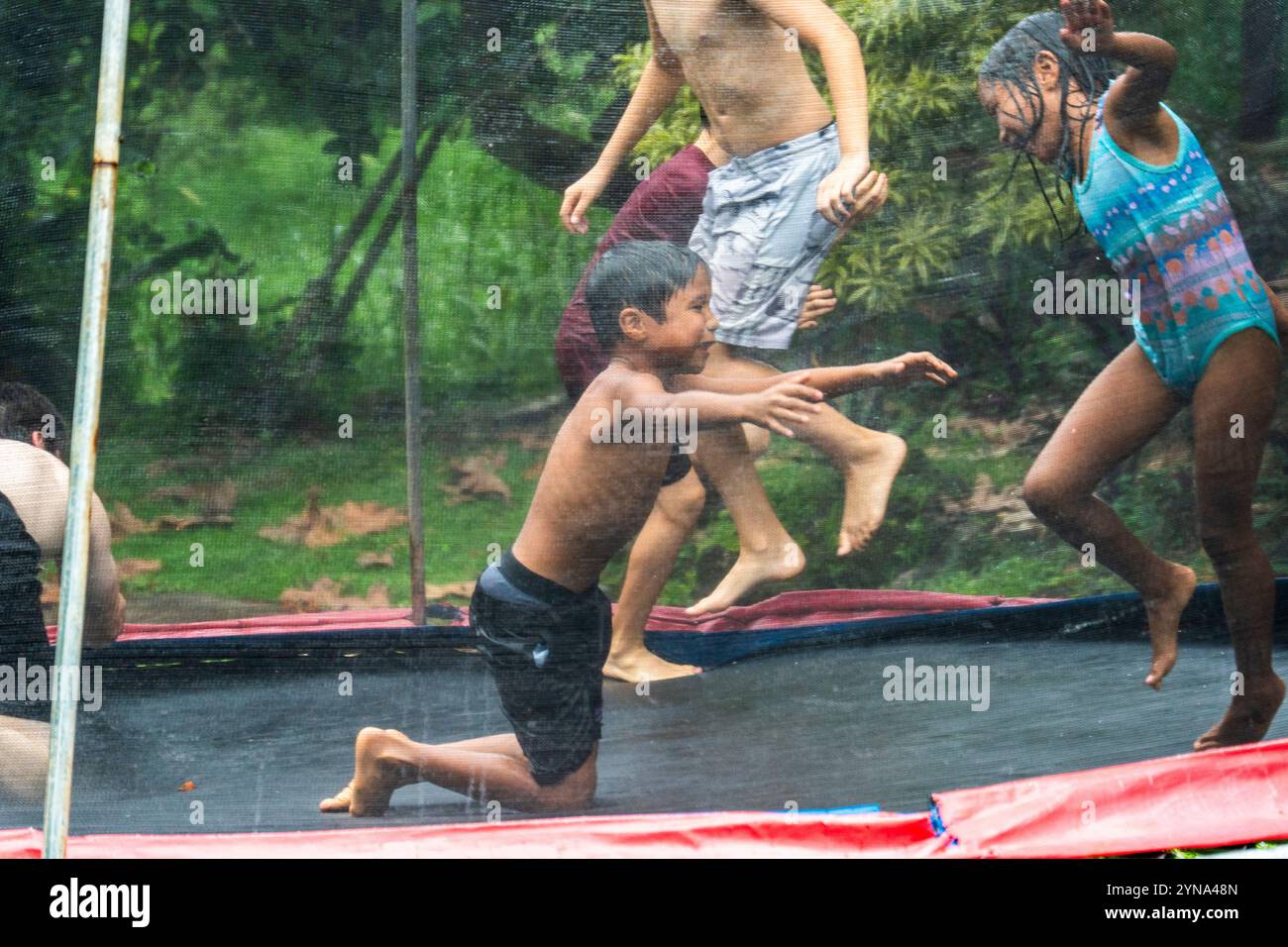 Fröhliche Kinder spielen an einem sonnigen Tag auf einem Wassertrampolin in Guam Stockfoto