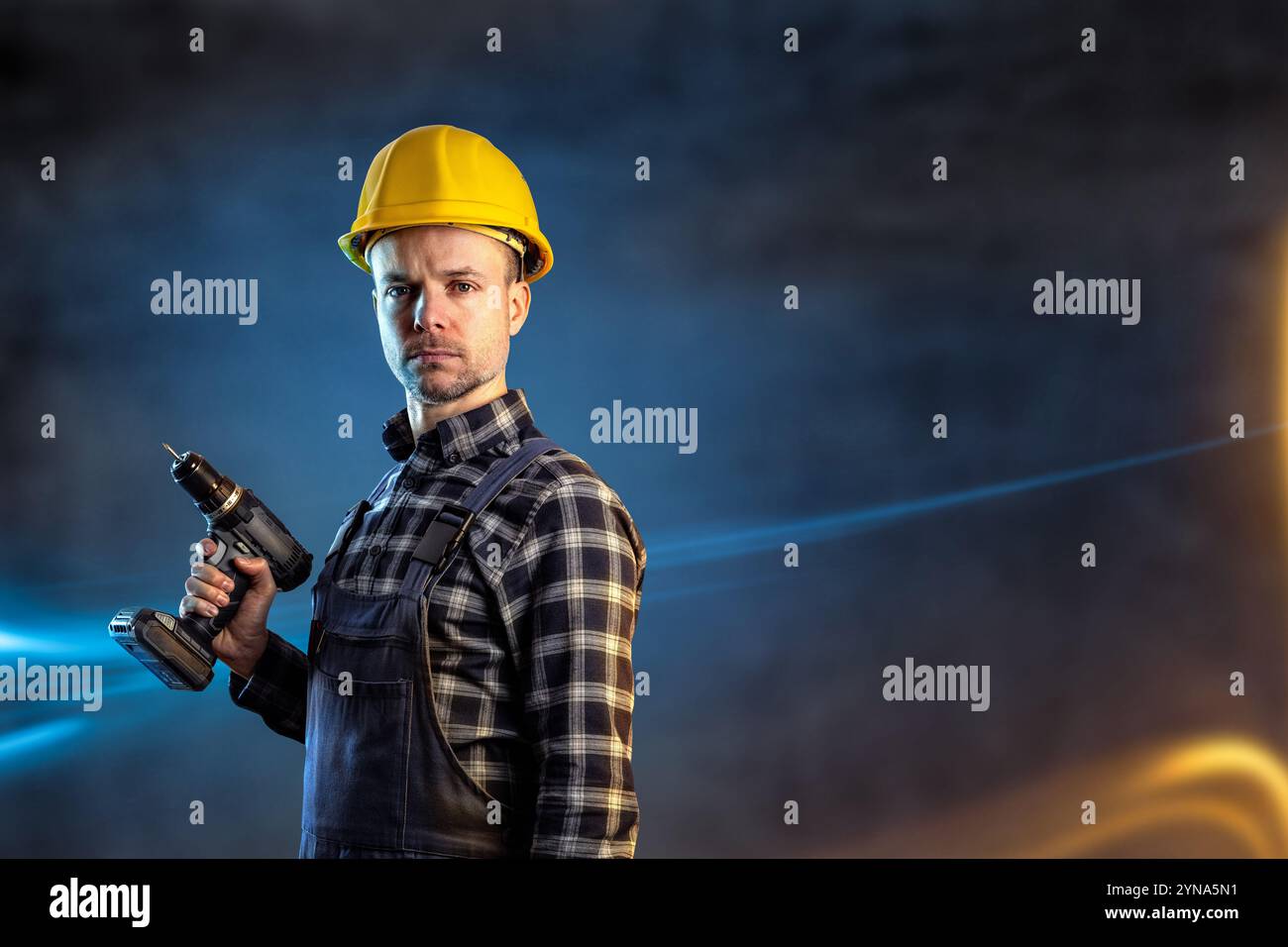 Porträt eines Bauherstellers mit einem Schutzhelm, der einen Akkuschrauber hält Stockfoto