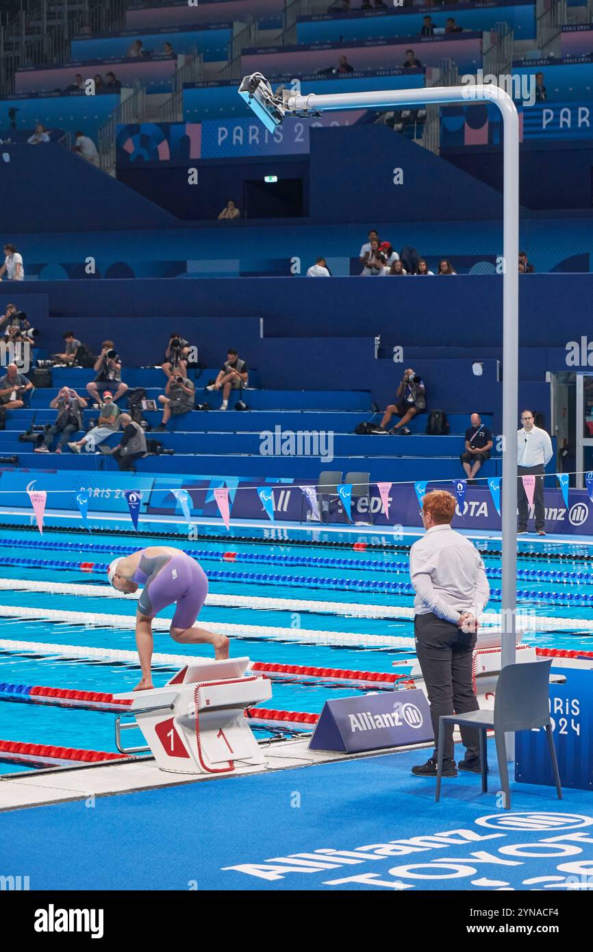 Frankreich, Hauts de seine, La Defense, La Defense Arena Schwimmbad, das exklusiv für die Olympischen und Paralympischen Spiele 2024 in Paris installiert wurde, Para-Schwimmveranstaltungen, Schwimmerin mit Doppelarmamputierte am Startblock Stockfoto