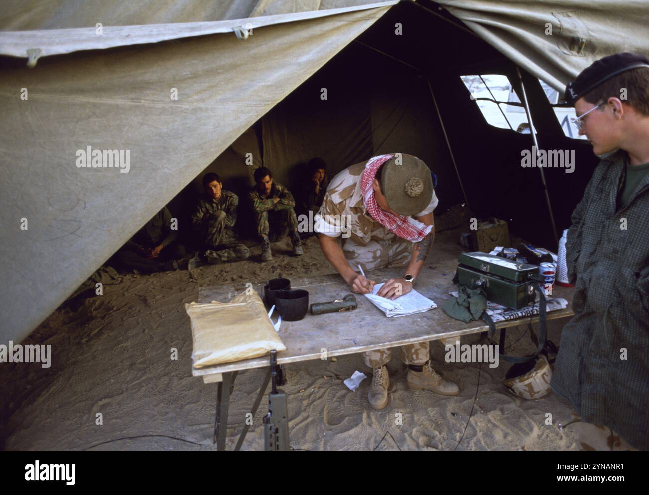 Erster Golfkrieg: 11. März 1991 Ein britischer Soldat der Highlanders der 1st Queen bewacht irakische Kriegsgefangene in einem Feldzelt im britischen Hauptquartier der Division in Kuwait. Stockfoto