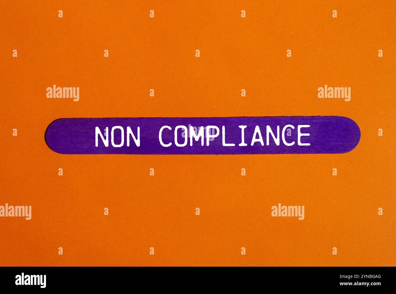 Meldung über Nichteinhaltung auf violettem Holzstab mit orangem Hintergrund. Symbol für konzeptionelle Nichteinhaltung. Kopierbereich. Stockfoto