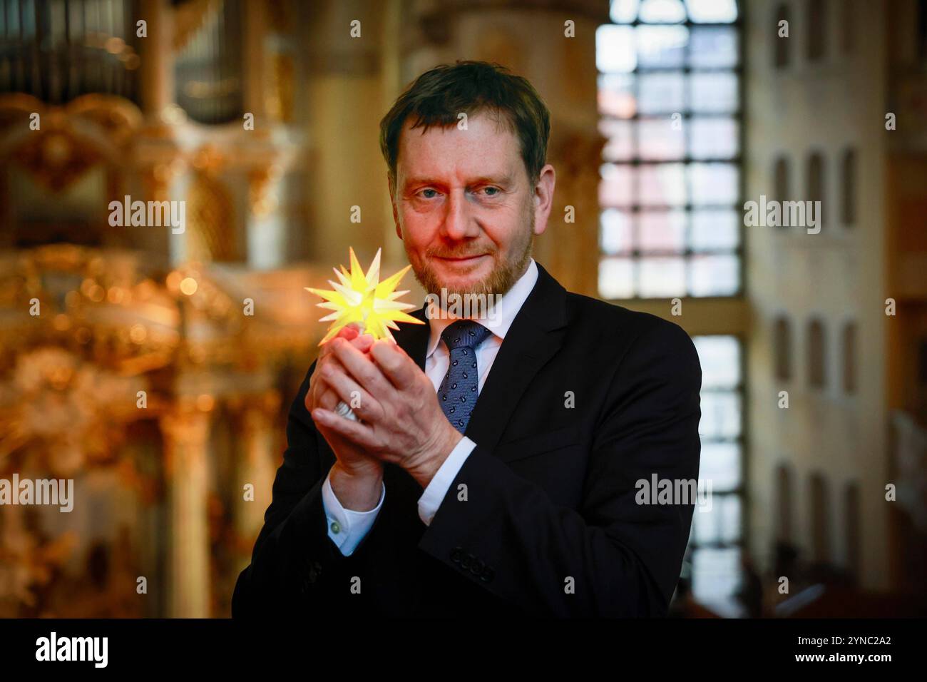 Praesentation der neuen Herrnhuter Sterne Edition Frauenkirche Dresden in der Frauenkirche in Dresden. Foto vom 25.11.2024: Der saechsische Ministerpraesident Michael Kretschmer CDU hat das erste Exemplar uebergeben bekommen das Modell Frauenkirche Dresden der ostsaechsischen Herrnhuter Sterne GmbH leuchtet in den Farben gelb und weiß. Anlass ist die 20-jaehrige Zusammenarbeit der Stiftung Frauenkirche Dresden und der Herstellerin der traditionsreichen Herrnhuter Sterne. Bereits 2004, ein Jahr vor der feierlichen Weihe der wiederaufgebauten Dresdner Frauenkirche, stellte die Herrnhuter Firma Stockfoto