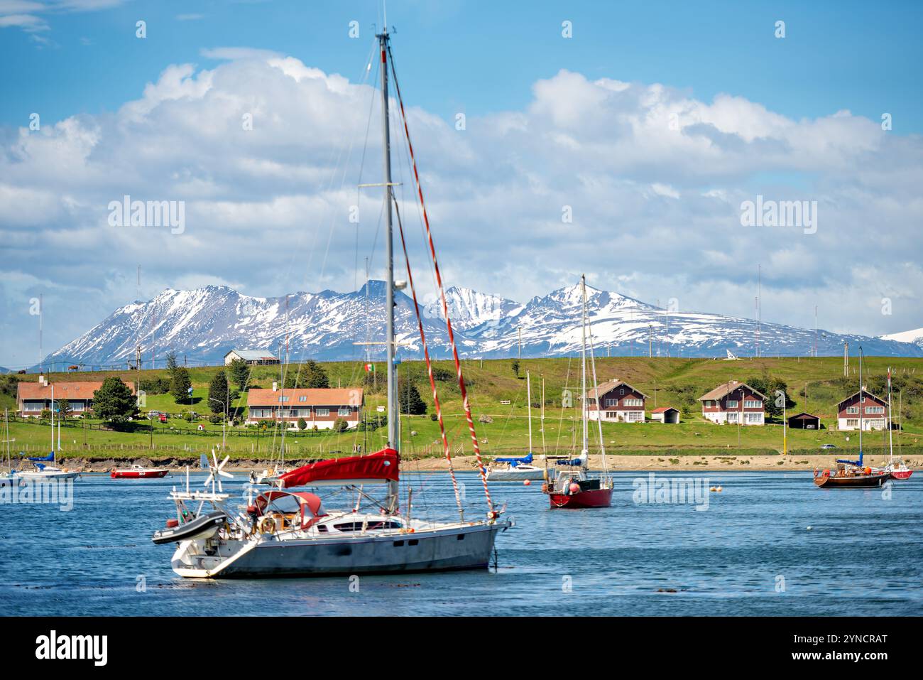 Beagle Channel Segelboote Ushuaia Argentina // USHUAIA, Argentinien — die südlichste Stadt der Welt liegt zwischen den Martial Mountains und dem Beagle Channel in Tierra del Fuego. Ushuaia, bekannt als das „Ende der Welt“, ist ein wichtiges Tor für Antarktis-Expeditionen und Tourismus. Die farbenfrohen Gebäude der Stadt stehen im Kontrast zu den schneebedeckten Gipfeln, die ihre dramatische Kulisse bilden. Stockfoto